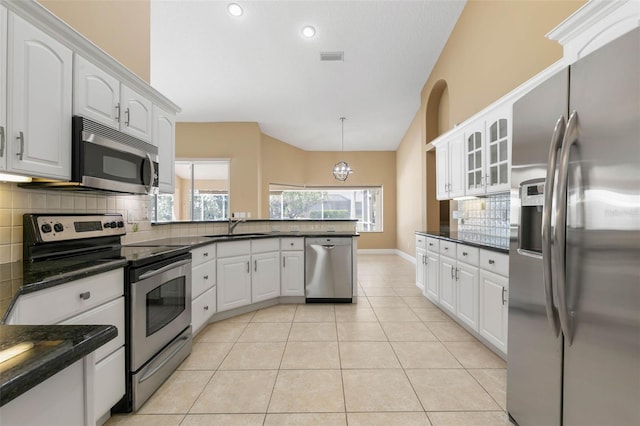 kitchen with hanging light fixtures, white cabinetry, glass insert cabinets, and stainless steel appliances