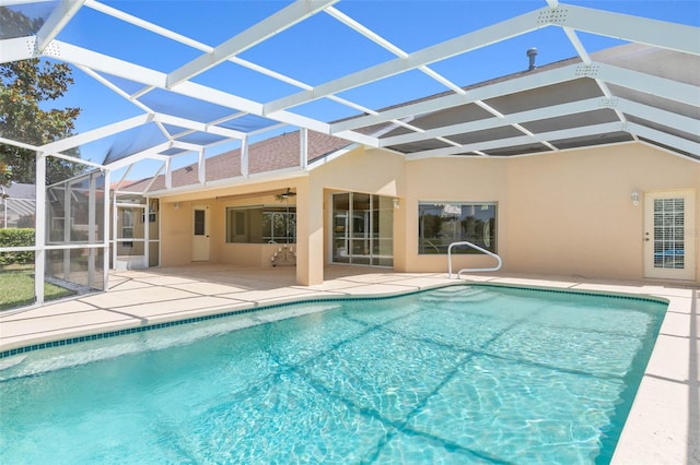 pool featuring ceiling fan, glass enclosure, and a patio area