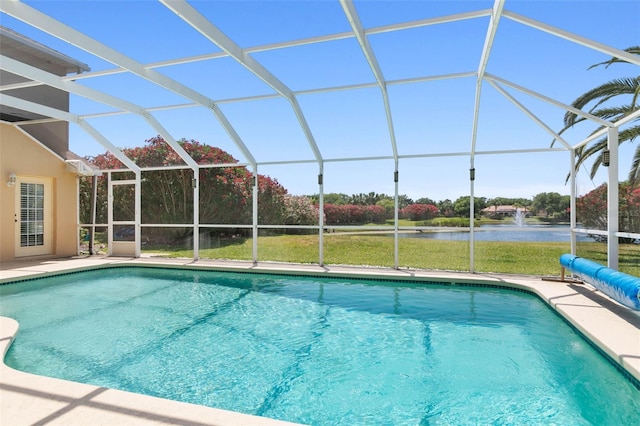 pool featuring a patio area, glass enclosure, and a water view