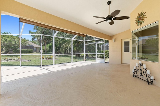 unfurnished sunroom with vaulted ceiling, ceiling fan, and plenty of natural light