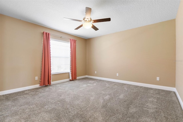 carpeted spare room with ceiling fan, a textured ceiling, and baseboards