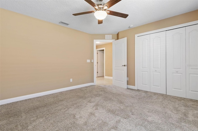 unfurnished bedroom with light carpet, baseboards, visible vents, and a textured ceiling