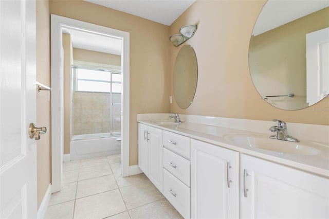 full bathroom with shower / bath combination with glass door, double vanity, a sink, and tile patterned floors