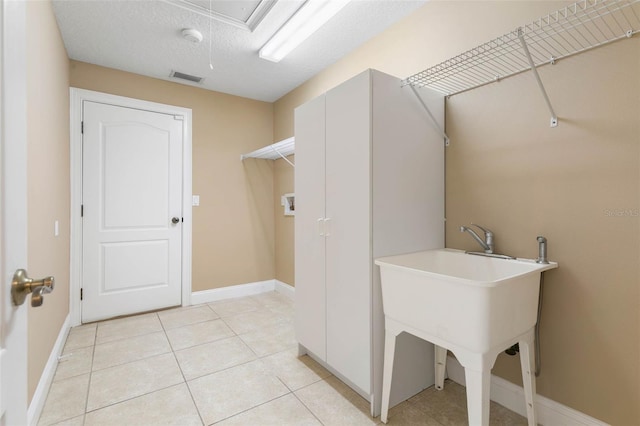 washroom with washer hookup, light tile patterned floors, visible vents, attic access, and laundry area