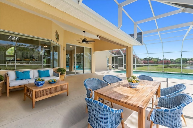 view of patio with a lanai, an outdoor pool, outdoor lounge area, and a ceiling fan