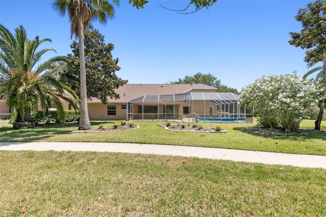 view of front of home featuring glass enclosure and a front yard