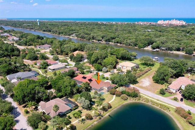 bird's eye view with a water view, a wooded view, and a residential view