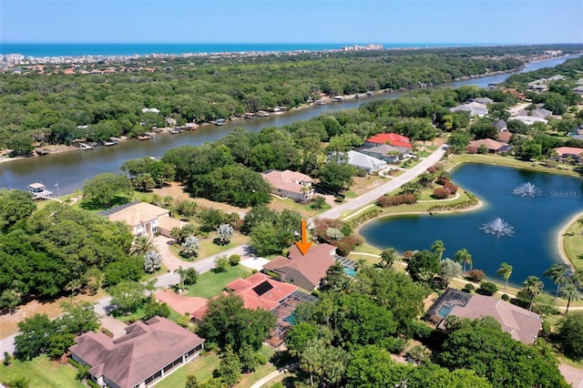 aerial view featuring a residential view, a water view, and a view of trees