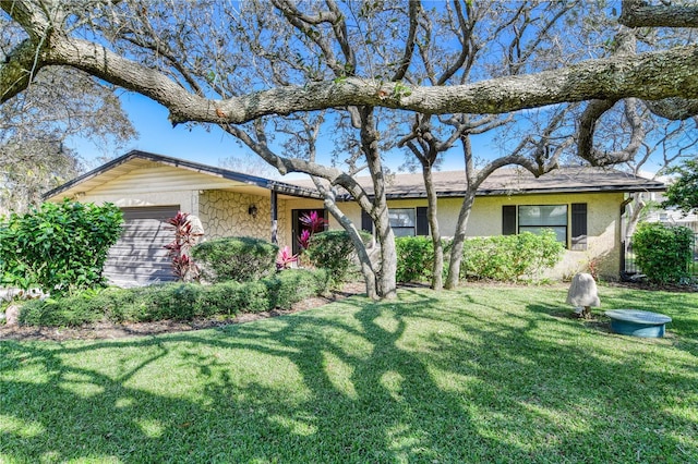 ranch-style house featuring a front lawn and a garage