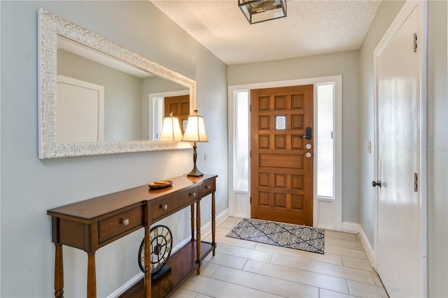 foyer entrance with a textured ceiling