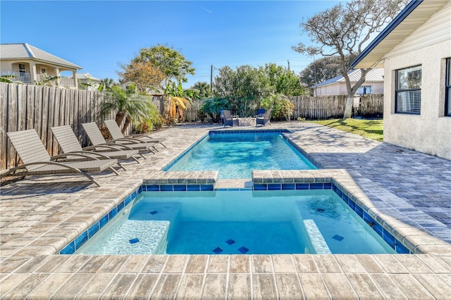 view of pool with a patio area and an in ground hot tub