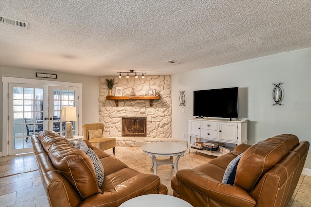 tiled living room with a fireplace, french doors, and a textured ceiling