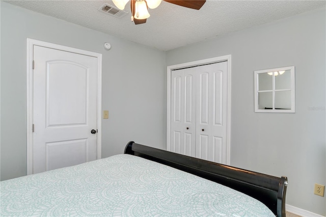 bedroom with ceiling fan, a closet, and a textured ceiling