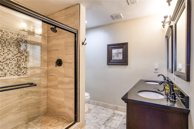 bathroom with vanity, toilet, and a shower with door