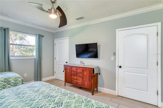 bedroom with light tile patterned floors, a textured ceiling, ceiling fan, and crown molding