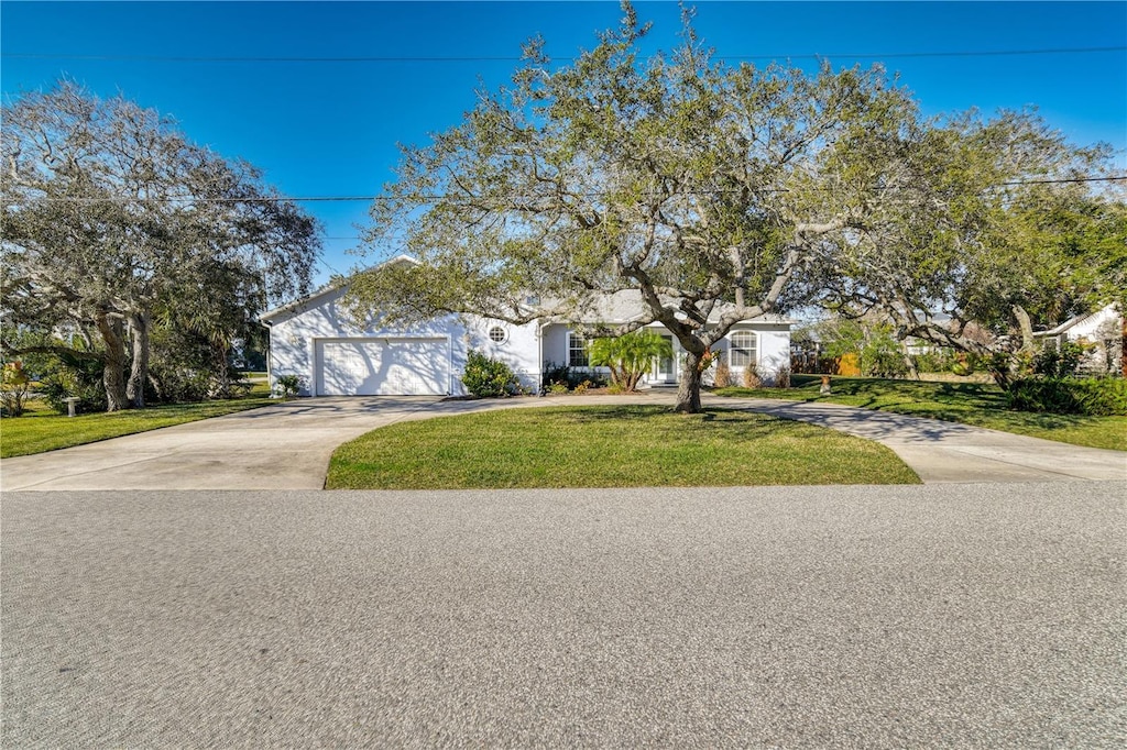 obstructed view of property featuring a garage and a front lawn