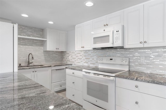 kitchen with stone countertops, sink, backsplash, white cabinets, and white appliances