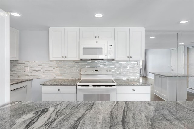 kitchen featuring light stone counters, white appliances, and white cabinets