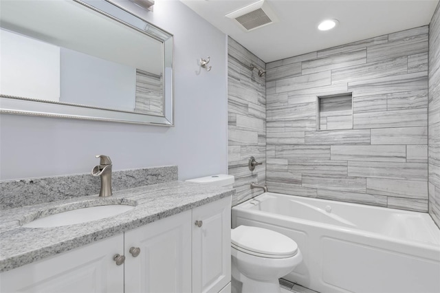 full bathroom featuring tiled shower / bath combo, vanity, and toilet