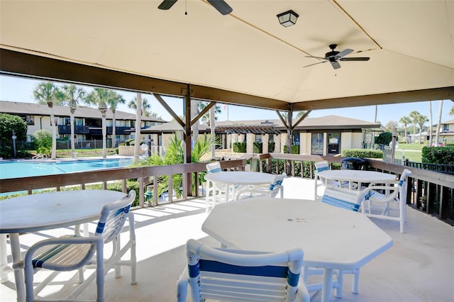 view of patio with a community pool and ceiling fan