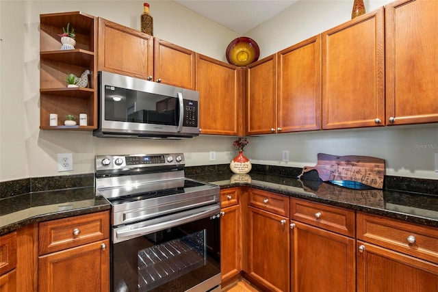 kitchen with dark stone countertops and appliances with stainless steel finishes