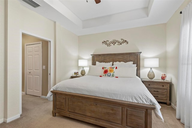 bedroom featuring a tray ceiling, ceiling fan, and light colored carpet