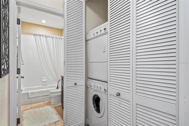 laundry area featuring light tile patterned floors and stacked washer / dryer