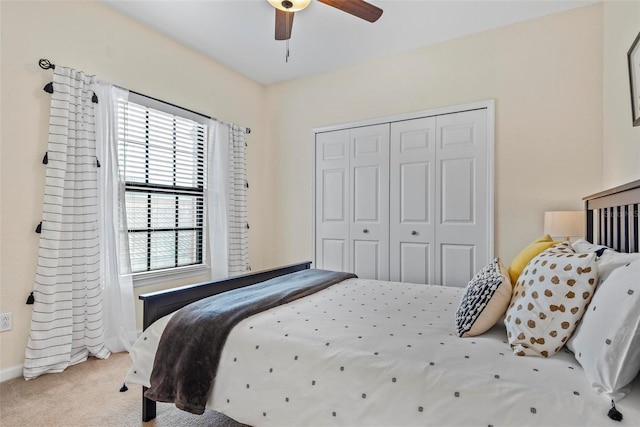 carpeted bedroom with ornate columns, ceiling fan, and a closet