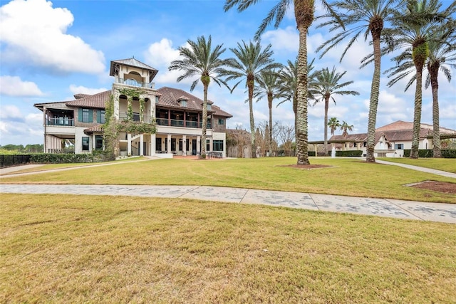 view of front of home with a balcony and a front yard