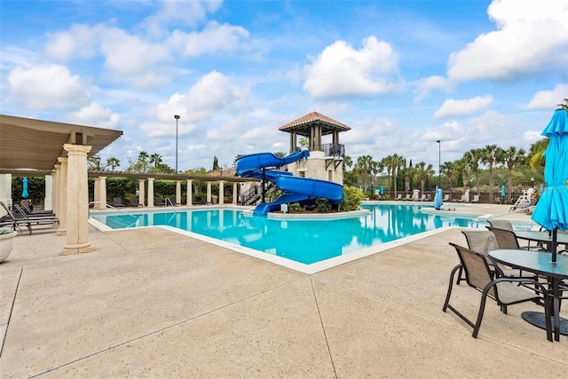 view of swimming pool with a water slide and a patio