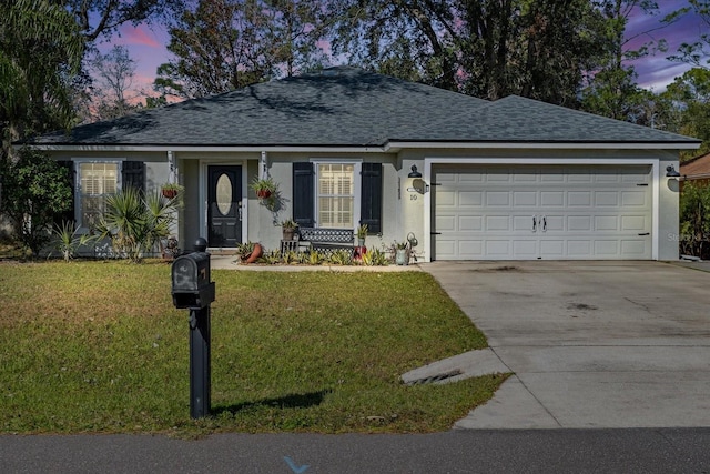 single story home with a garage and a lawn