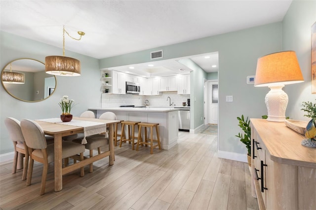 dining space with light wood-type flooring, baseboards, visible vents, and recessed lighting