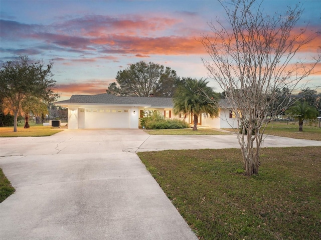 ranch-style home with a yard and a garage