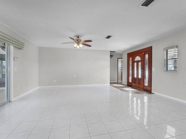 entrance foyer with a wealth of natural light, ceiling fan, light tile patterned floors, and a textured ceiling