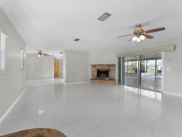 unfurnished living room featuring ceiling fan, light tile patterned floors, and a brick fireplace