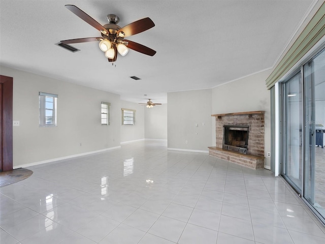 unfurnished living room with a textured ceiling, a brick fireplace, ceiling fan, and light tile patterned flooring