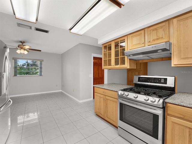 kitchen with light brown cabinets, ceiling fan, light tile patterned floors, light stone countertops, and appliances with stainless steel finishes