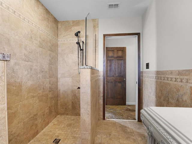 bathroom featuring tile walls and tiled shower