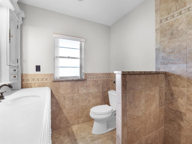 bathroom featuring tile patterned floors, sink, tile walls, and toilet