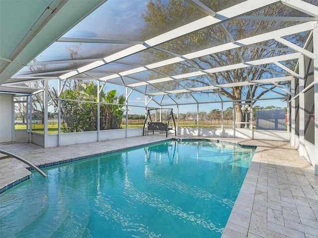 view of swimming pool with glass enclosure and a patio area