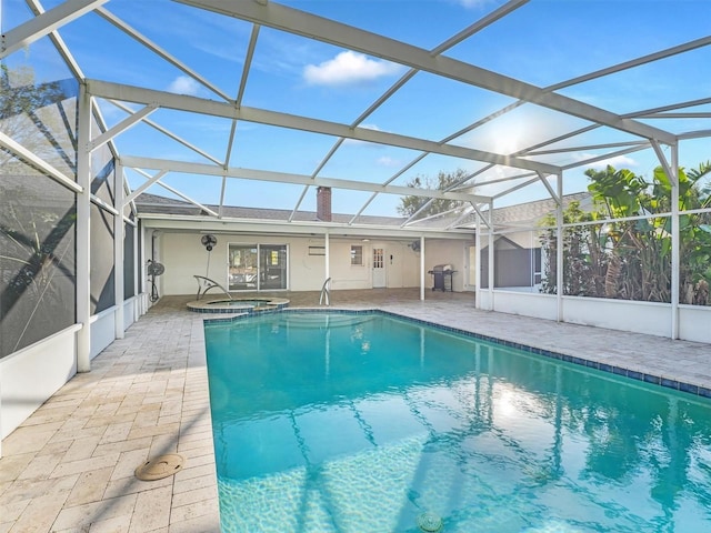 view of swimming pool featuring glass enclosure, grilling area, an in ground hot tub, and a patio