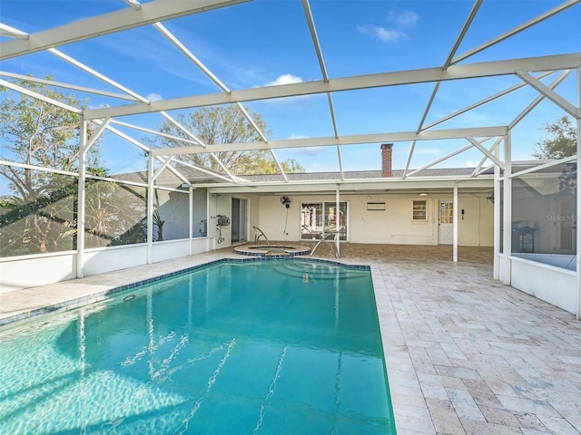 view of pool with a patio area, a lanai, and an in ground hot tub