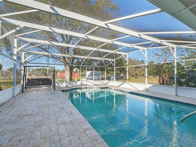 view of pool with a patio and glass enclosure