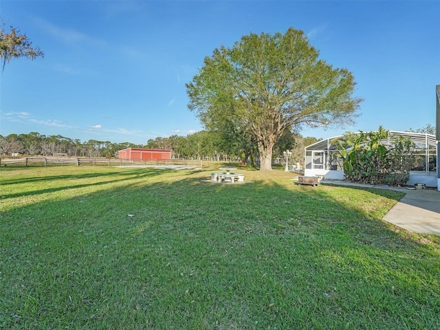 view of yard featuring a fire pit and glass enclosure