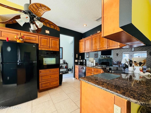 kitchen featuring ceiling fan, exhaust hood, kitchen peninsula, a textured ceiling, and black appliances