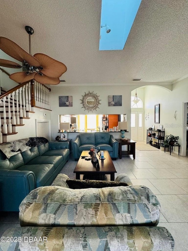 tiled living room with ceiling fan and a textured ceiling