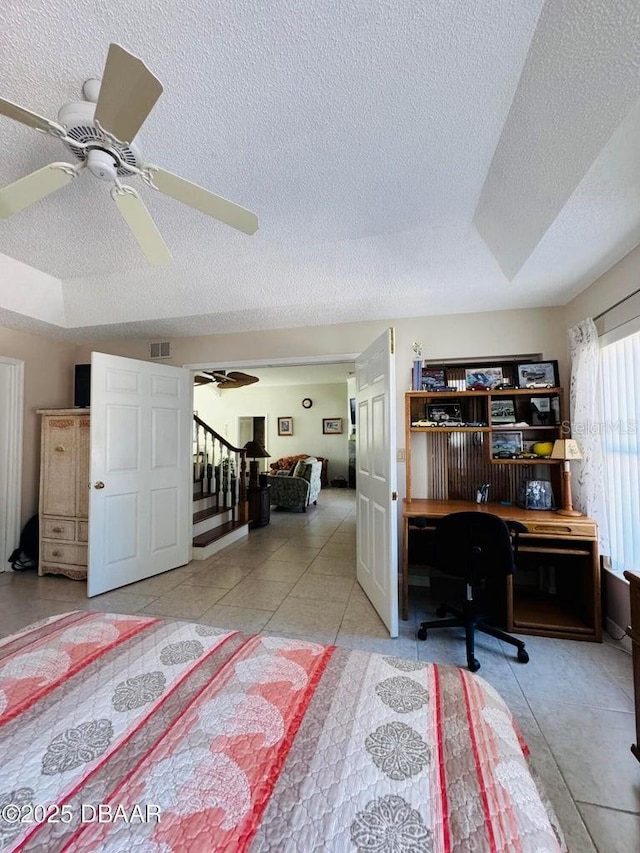 tiled bedroom with a textured ceiling and a raised ceiling