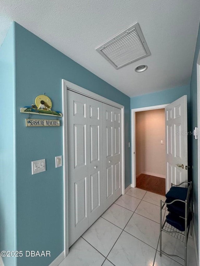 hall featuring a textured ceiling