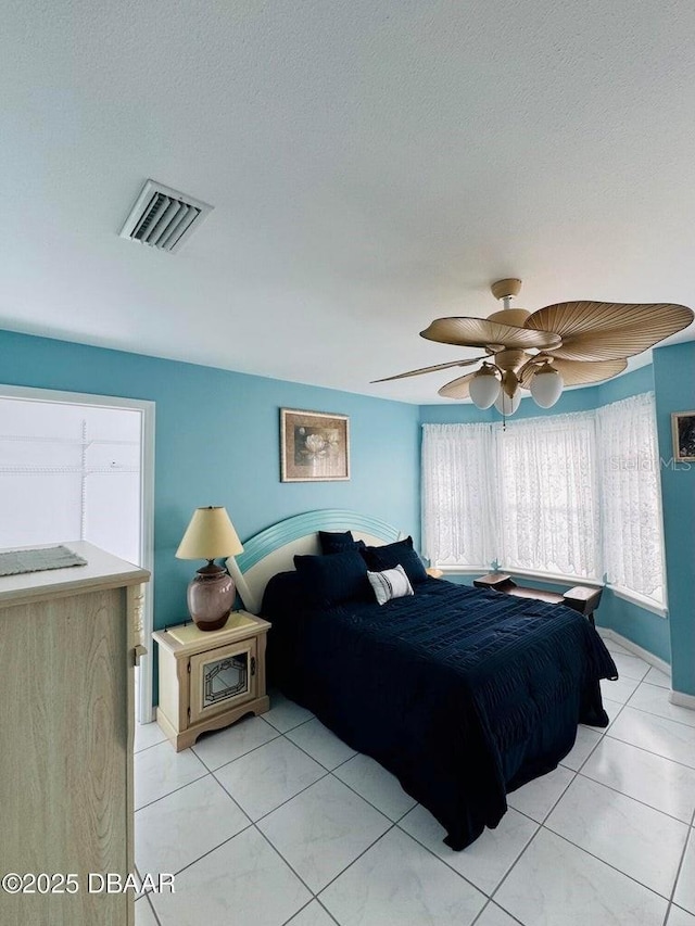 bedroom featuring light tile patterned floors, a textured ceiling, and ceiling fan