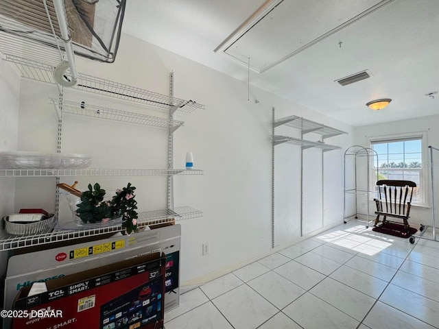 walk in closet with light tile patterned floors